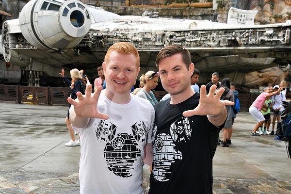 Two LGBT travelers posing in front of the Millennium Falcon at Walt Disney World Resort