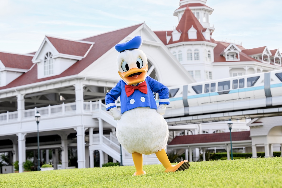 A smiling mother and two young children happily walk around Disney's Grand Floridian Resort & Spa.